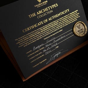 May include: A black certificate of authenticity for The Archetypes Collection by Valora Home. The document features gold text, a gold wax seal with the Valora Home logo, and handwritten details including the owner name, model, date, and edition number.