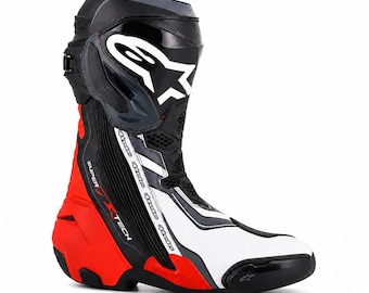 Könnte beinhalten: Ein leistungsstarker Motorrad-Rennstiefel in den Farben Schwarz, Weiß und Rot. Der Stiefel verfügt über das Alpinestars-Logo auf dem Schienbeinschutz, ein Supertech-Etikett an der Seite und einen verstärkten Zehenschleifer in technischem Design.