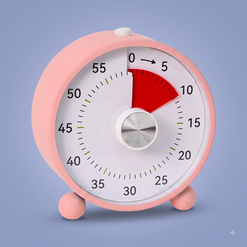 May include: A round, light pink visual timer with a white face, black numerals from 0 to 55, and a central silver knob. A red wedge indicates the elapsed time between 0 and 10 minutes. The device features two small, round, light pink feet.