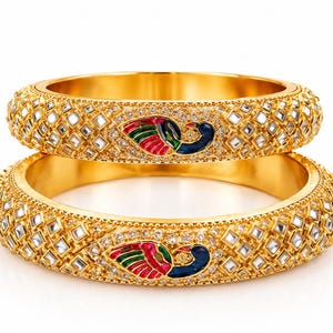Puede incluir: Dos brazaletes dorados con un motivo central de pavo real con detalles en esmalte azul, verde y rojo. La superficie está decorada con un patrón repetitivo de diamantes con piedras transparentes incrustadas y pequeñas cuentas doradas.