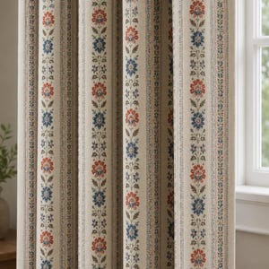 May include: A beige curtain panel featuring vertical stripes with a repeating floral pattern in shades of red, blue, and green. The fabric displays a textured weave with alternating bands of intricate botanical motifs and thin dotted lines.