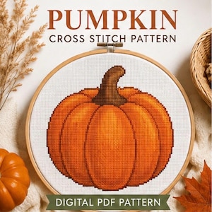 Può includere: Un telaio da ricamo rotondo in legno contenente tessuto bianco con un motivo a punto croce di una zucca arancione con un picciolo marrone. Il testo PUMPKIN CROSS STITCH PATTERN è in alto e DIGITAL PDF PATTERN è in basso.
