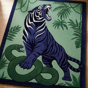 Peut inclure: Un tapis rectangulaire représentant un tigre bleu foncé aux rayures blanches rugissant face à un serpent vert. Le fond est un champ vert clair avec des feuilles de palmier et des vignes vert foncé, encadré par une bordure bleu foncé.