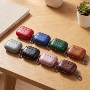 Peut inclure: Un ensemble de huit étuis rectangulaires pour écouteurs avec un motif texturé en relief façon crocodile. Les étuis sont disponibles en rouge, bleu, vert, marron, gris, noir, rose et beige, chacun muni d'un petit mousqueton en métal sur le côté.