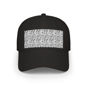 May include: A black baseball cap featuring a rectangular patch on the front panel. The patch displays a dense, repeating black and white graphic pattern composed of numerous small, detailed manga-style character illustrations.