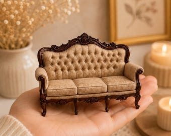 May include: A miniature sofa featuring a dark brown wooden frame with ornate carved details and a beige tufted fabric upholstery. The piece has a curved backrest, rolled arms, and four carved legs, showcasing a detailed pattern on the fabric.