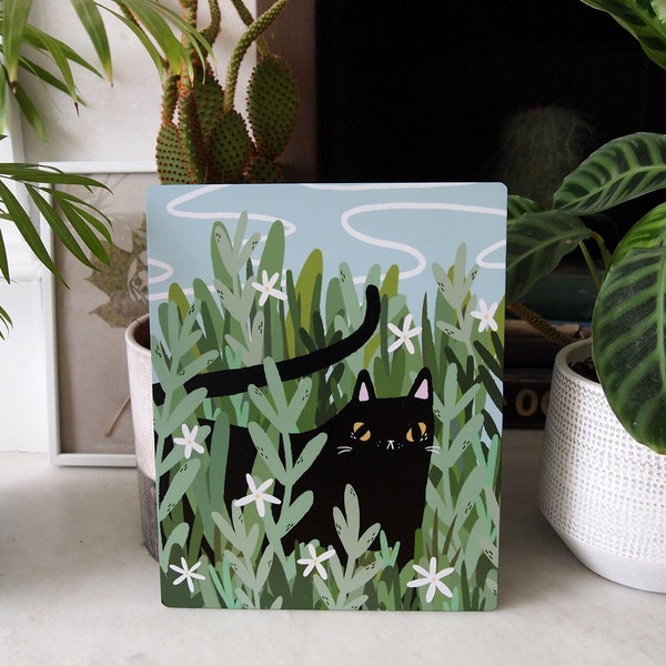 Black cat in the shrubs metal art print