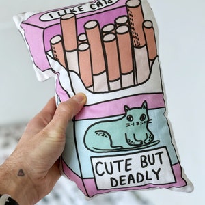 Cojín de peluche de gato lindo pero mortal, cigarrillos novedosos