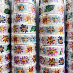 Peut inclure: Rouleaux de ruban adh&eacute;sif washi color&eacute; avec un motif r&eacute;p&eacute;titif de chats et de fleurs. Le ruban porte l'inscription "J'aime les chats".