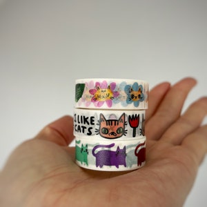 Peut inclure: Un lot de quatre rubans washi avec des illustrations color&eacute;es de chats et le texte "J'aime les chats".
