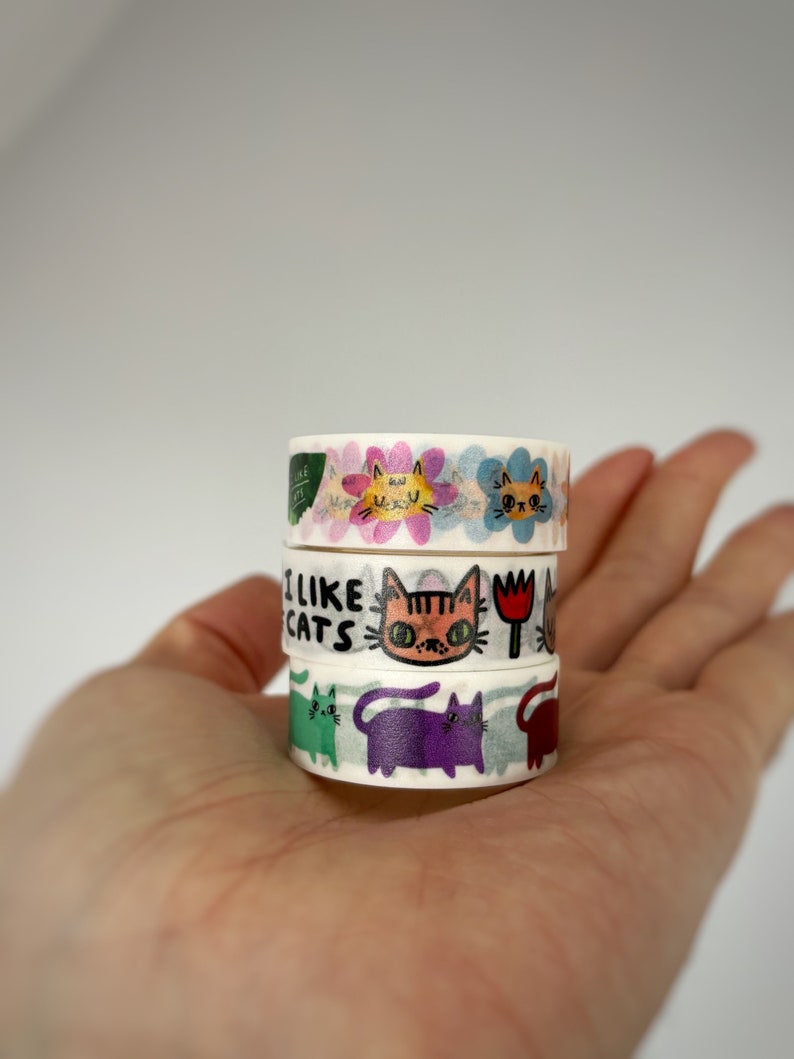 Peut inclure: Un lot de quatre rubans washi avec des illustrations color&eacute;es de chats et le texte "J'aime les chats".