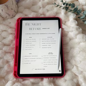 May include: A tablet in a bright pink case displaying a digital checklist titled The Night Before Check List, with categories for work, childcare, home, and before you sleep. A white stylus rests on the screen, which lists tasks like work bag packed, nursery bag packed, and breakfast prepared.