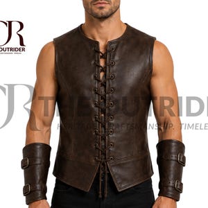 May include: A dark brown leather vest featuring a front lace-up closure with metal eyelets and matching brown leather forearm bracers with two metal buckles each. The text "CR THE OUTRIDER HERITAGE CRAFTSMANSHIP. TIMELESS." is visible in the upper left corner.