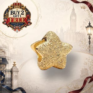 May include: A gold-toned star-shaped charm bead with a textured, glittery surface. The bead features a central hole for threading onto a bracelet or necklace chain. The design is five-pointed with rounded edges and a metallic finish throughout.
