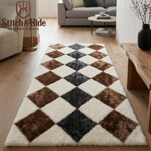 May include: A rectangular area rug featuring a repeating diamond pattern in cream, brown, and dark gray. The rug has a plush, textured surface and is laid out on a light-colored wooden floor, showcasing a geometric design with alternating colors.