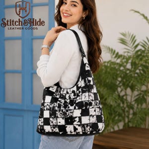 May include: A shoulder bag featuring a black and white checkered pattern with a textured, fur-like finish. The bag has a single black strap and is branded with the Stitch & Hide Leather Goods logo in the upper left corner of the image.