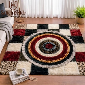 Pode incluir: Um tapete retangular com um design de patchwork de quadrados pretos, brancos, vermelhos e com estampa de leopardo. O centro exibe uma série de círculos concêntricos em tons de vermelho, preto, branco e castanho, com pelo longo e texturizado.