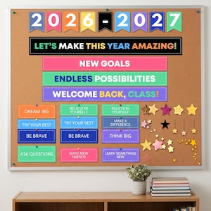Puede incluir: Un tablón de anuncios de corcho con banderines coloridos que muestran 2026-2027, un letrero negro que dice LET'S MAKE THIS YEAR AMAZING! y varias etiquetas rectangulares con frases motivadoras como NEW GOALS, DREAM BIG y BE BRAVE, además de estrellas.
