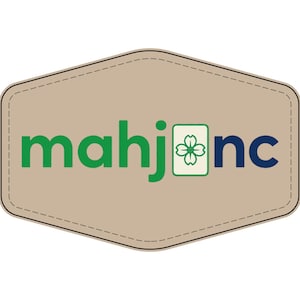 May include: A beige, hexagon-shaped patch with stitched edges featuring the green text 'mahj' followed by a white tile icon with a green flower design, and the blue text 'nc' to the right, forming the logo 'mahjnc' on a tan background.