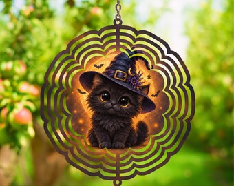 May include: A circular metal wind spinner featuring a black kitten wearing a purple witch hat with a gold buckle and crescent moon. The kitten is centered against a glowing orange moon background with small black bats and purple flowers.