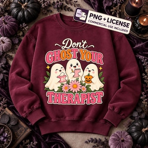 May include: A maroon crewneck sweatshirt featuring a graphic of three white ghosts with pink flowers. The text reads "Don't GHOST YOUR THERAPIST" in pink and orange letters. One ghost holds a tissue box, one a notepad, and one a pumpkin.