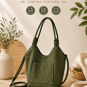 Puede incluir: Un patrón de costura para bolso de hombro en color verde oliva oscuro con el texto SHOULDER BAG SEWING PATTERN e iconos de A4, A0 e impresora. El bolso tiene un bolsillo exterior central, dos asas con nudos y una correa larga.