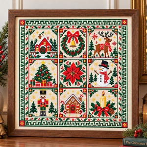 May include: A framed cross-stitch sampler featuring a grid of nine Christmas-themed squares, including a red house, a wreath, a reindeer, a decorated tree, a poinsettia, a snowman, a nutcracker, a gingerbread house, and a candle.