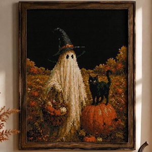 May include: A framed cross-stitch artwork depicting a white ghost wearing a pointed witch hat and carrying a basket, standing next to a black cat perched on a large orange pumpkin in an autumn field with a dark black sky background.