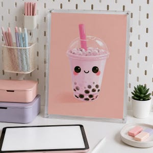 Peut inclure: Une impression d'art encadrée représentant un thé aux perles rose clair avec un visage souriant, des perles de tapioca foncées et une paille rose vif. L'illustration est sur fond rose uni, présentée dans un cadre en acrylique transparent.