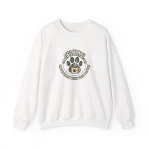 Könnte beinhalten: Ein weißes langärmeliges Sweatshirt mit Rundhalsausschnitt und einem zentralen Aufdruck. Das Design zeigt einen dunkelgrauen Pfotenabdruck, eine beigefarbene Kaffeetasse mit Pfotensymbol sowie den Text: AFTER THE WALK COMES THE BEST PART, COFFEE THEN WALK THEN REPEAT.