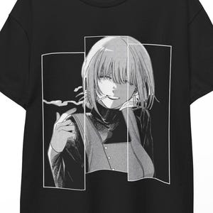 Op de afbeelding: Een zwart t-shirt met korte mouwen en een witte grafische print van een anime-figuur met kort haar die een sigaret vasthoudt. Het ontwerp is verdeeld in drie verticale rechthoekige panelen met een gedetailleerde, monochrome illustratie.