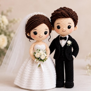 May include: Two crochet dolls representing a wedding couple. The figure on the left wears a white strapless dress, a veil with pearls, and holds a small bouquet of white flowers. The figure on the right wears a black suit with a white shirt and bow tie.