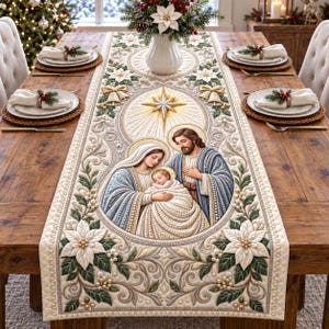 May include: A cream-colored fabric table runner featuring a central embroidered scene of the Nativity with Mary, Joseph, and the infant Jesus. The design includes gold star accents, white poinsettia flowers, green leaves, and gold bells.
