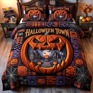 May include: A Halloween Town bedding set featuring a large central jack-o'-lantern graphic with a spooky house scene inside. The quilt and two matching pillowcases display orange, black, and purple patchwork patterns with spiders, webs, and bats.