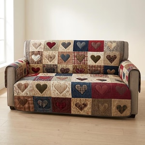 May include: A sofa cover featuring a patchwork design of quilted squares, each displaying a heart motif in various colors including red, blue, brown, and cream. The fabric has a textured appearance with visible stitching throughout the pattern.