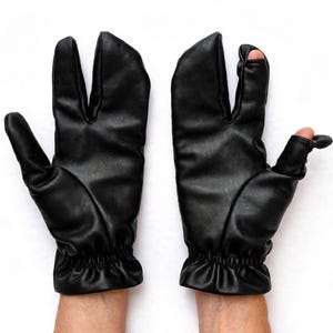 Könnte beinhalten: Ein Paar schwarze Lederhandschuhe mit einem speziellen Design mit getrennten Fingern. Der linke Handschuh hat einen abgetrennten Zeigefinger, während der rechte Handschuh einen freiliegenden Daumen und Zeigefinger hat, beide mit gerafften Gummibündchen.