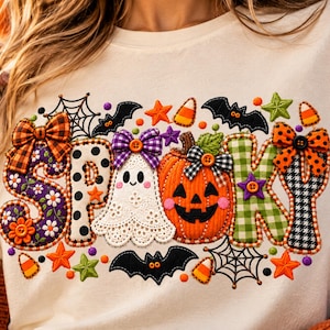Może przedstawiać: Kremowy t-shirt z dużą grafiką układającą się w napis SPOOKY. Litery ozdobione są różnymi wzorami, kokardkami i guzikami. Wzór zawiera białego duszka, pomarańczową dynię, nietoperze, pajęczyny oraz gwiazdki.