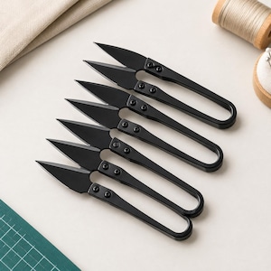 May include: A set of six black metal thread snips arranged in a diagonal row. Each tool features a pointed blade, a spring-loaded mechanism, and a continuous loop handle secured with two small screws near the pivot point for precise cutting.