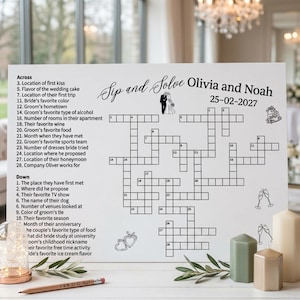 Puede incluir: Un letrero rectangular blanco de crucigrama para bodas titulado Sip and Solve Olivia and Noah 25-02-2027. Presenta texto negro con pistas numeradas, una cuadrícula central y pequeñas ilustraciones de líneas negras de una pareja, un pastel y copas de champán.