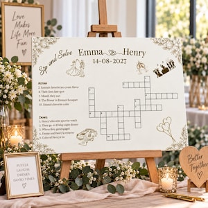 Puede incluir: Un cartel de boda blanco con crucigrama sobre un caballete de madera con el texto Sip and Solve, Emma and Henry y la fecha 14-08-2027. El tablero incluye dibujos lineales dorados de una pareja bailando, copas de champán y globos.