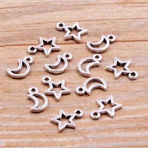 May include: A collection of silver-toned metal charms featuring crescent moon and star shapes. The charms have a loop at the top for attaching to jewelry or other crafts.
