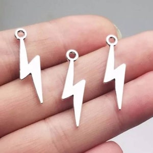 May include: Three silver lightning bolt charms with a loop at the top for attaching to jewelry or other crafts.