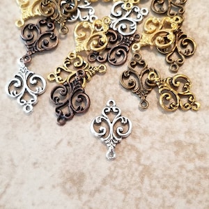 May include: A collection of ornate metal charms in silver, gold, and bronze finishes. Each charm features a delicate, intricate design with swirling patterns. These charms are perfect for adding a touch of elegance to jewelry, crafts, or other projects.