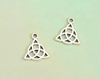 May include: Two silver-colored Celtic knot charms. Each charm features a triangular shape with an interwoven knot design and a small loop at the top for attaching to jewelry or other crafts. The background is a soft green.