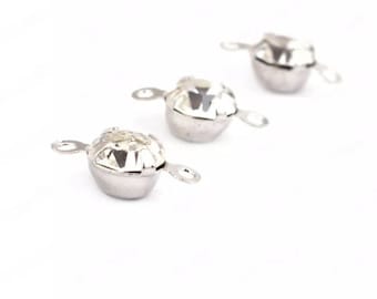 May include: Three silver-toned jewelry components with a faceted, clear crystal center. Each component has a rounded base and two small, curved loops extending from the sides. The crystals sparkle against the white background.
