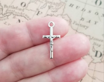 May include: A silver-toned crucifix charm with a detailed figure of Jesus Christ on the cross.