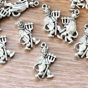 May include: Silver charm pendants featuring a devil figure holding a trident. The charms have a detailed design and are perfect for adding a touch of whimsy to jewelry.