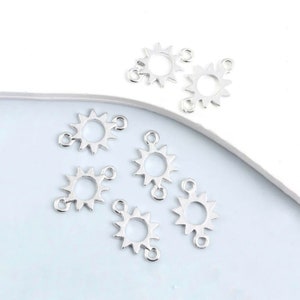 May include: Silver-toned metal sun charm connectors with a loop on each side. These charms are perfect for adding a touch of whimsy to jewelry making projects.