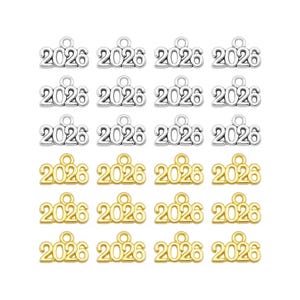May include: A collection of silver and gold-colored charms, each displaying the number "2026". The charms are small, with a loop at the top for attaching to jewelry or other crafts. The charms are arranged in rows.