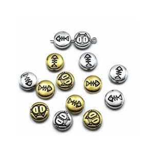 May include: A collection of silver and gold metal beads with a fishbone and cat face design. The beads are round and have a hole in the center for stringing.